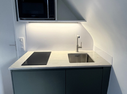 Kitchenette sur mesure granit Mont Blanc et façades vertes Paris 4e