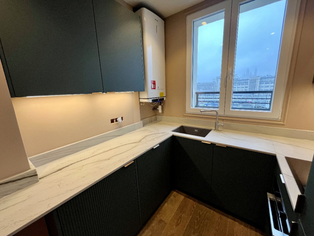 Cuisine sur mesure Paris 10e avec granit Mont Blanc et façades polymère vert satiné