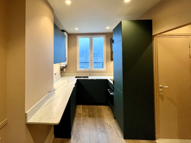 Cuisine sur mesure Paris 10e avec granit Mont Blanc et façades polymère vert satiné