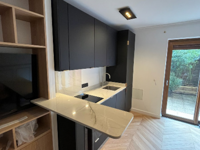 Cuisine équipée noire avec plan de travail en granit White Macaubas à Vincennes