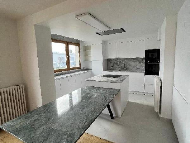 Cuisine ouverte sur mesure avec plans de travail et table en granit Paris 8e