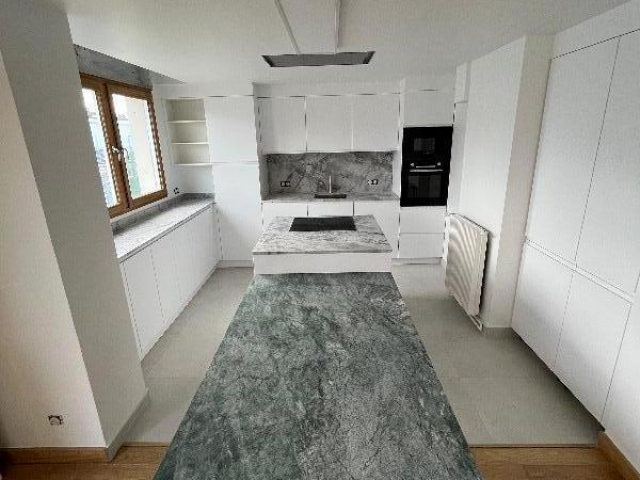 Cuisine ouverte sur mesure avec plans de travail et table en granit Paris 8e