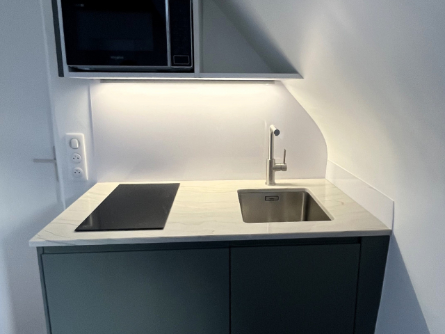 Kitchenette sur mesure granit Mont Blanc et façades vertes Paris 4e
