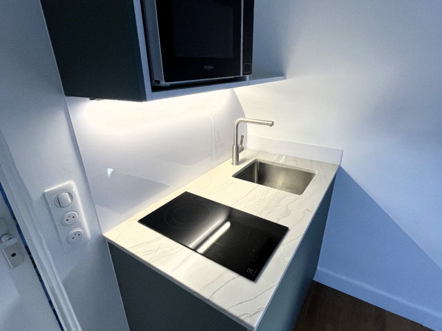 Kitchenette sur mesure granit Mont Blanc et façades vertes Paris 4e