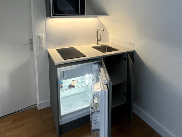 Kitchenette sur mesure granit Mont Blanc et façades vertes Paris 4e
